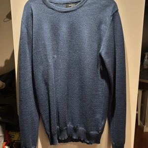 Blå stickad tröja - Säljer en stilren blå stickad tröja som jag inte har någon användning för längre. Ny pris 1200