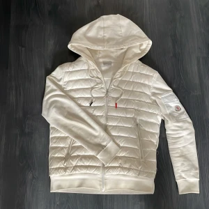 Vit moncler cardigan - Jag säljer min moncler cardigan för den börjar bli liten på mig och har använt den i cirka 2 månader nu. Den har inga stora defekter endast att den har lite mörkare vitt här å var för den är så pass använd men inget man märker till. Skicket är alltså 8/10 skulle jag säga och den är köpt för 8500. Säljer den betydligt mycket billigare och den är perfekt nu till våren sommaren och även hösten🙌 hör av er vid frågor🔥
