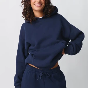 Mörkblå hoodie - Säljer en stilren mörkblå hoodie med en bekväm passform. Tröjan har en klassisk design med en stor ficka framtill och en rymlig huva. Perfekt för en avslappnad look.