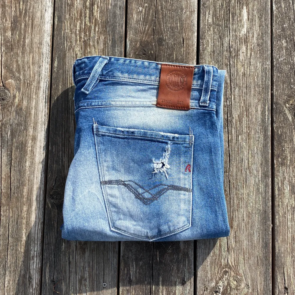 Snygga blå jeans från Replay med slitna detaljer och en klassisk femficksdesign. De har en straight passform och är perfekta för en avslappnad stil. W34 L32. Farkut & Housut.