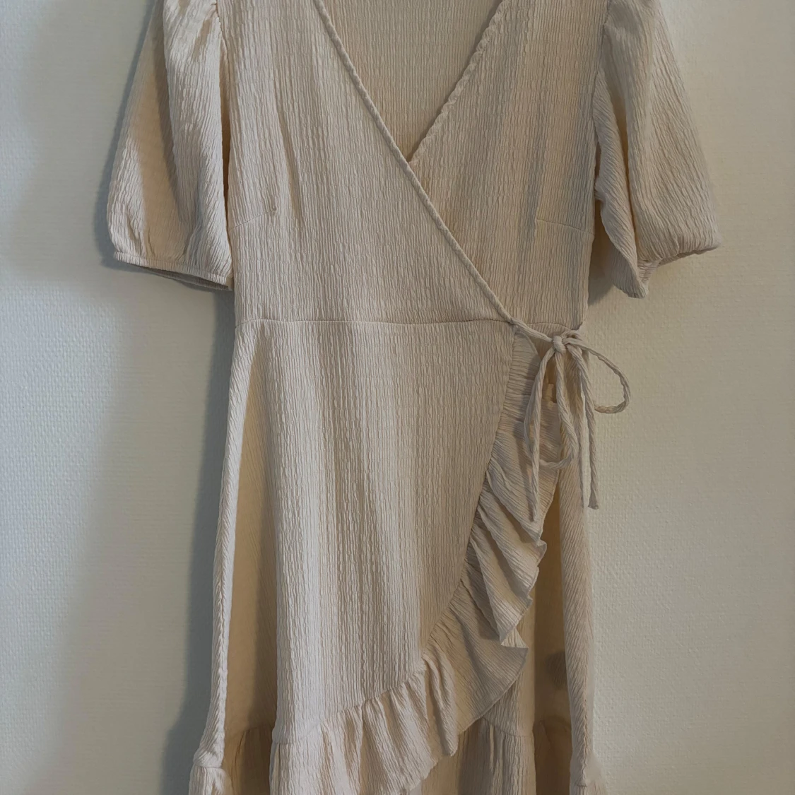 Beige omlottklänning med volang