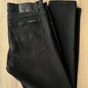 Svarta Nudie Jeans W31 L32 - Nudie Jeans av modell Tilted Tor. Snygga svarta jeans. Mycket fint skick. Tvätt: Dry Everblack. Hör av dig om du har några funderingar. En stor fördel med Nudies jeans jämfört mot Levis, Tiger of Sweden, Replay, Lee, Acne, dondup osv. är att du kan lämna in dem gratis för reparation eller uppläggning i Stockholm, Göteborg eller Malmö. På så vis förlängs livslängden rejält