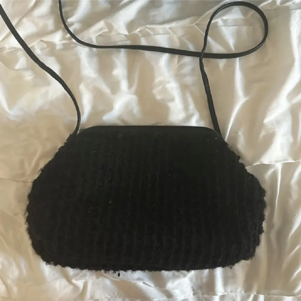 Snygg svart axelväska med quiltad design och justerbar axelrem. Väskan har en rymlig insida med ljus foder och innerficka. Perfekt för att bära dina dagliga nödvändigheter då du får plats med allt du behöver.. Laukut & Käsilaukut.
