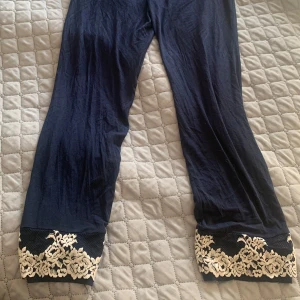 Mörkblå intimissimi byxor med spetsdetaljer - Snygga mörkblå byxor från Intimissimi med vackra spetsdetaljer vid bensluten. Perfekta för en elegant look. Byxorna har en rak passform och är tillverkade i ett mjukt material för extra komfort. Nästan oanvända kostar 500kr original