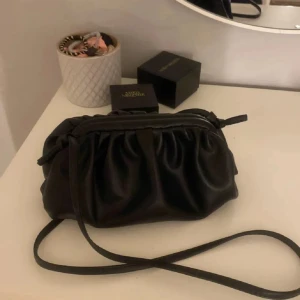 !lånad bild! Svart dumplingväska - Snygg svart dumplingväska.. Väskan har en stilren design med rynkade detaljer och en justerbar axelrem. Perfekt för att bära dina nödvändigheter med stil.