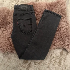 Svarta Levis 512 Slim Taper jeans - Snygga svarta Levis 512 Slim Taper jeans med en modern passform. De har en klassisk femficksdesign och en diskret Levis-logga på bakfickan. Perfekta för en stilren look. Är 170 och har på mig de. 