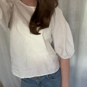 Vit puffärmsblus  - En vit blus med puffiga trekvartsärmar och en söt knytning i nacken. 