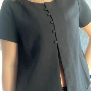 Gina topp med knappar  - Snygg topp med korta ärmar och knappar framtill. Endast använd ett fåtal gånger