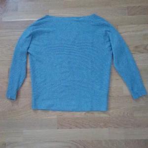 Blå ribbad tröja - Säljer en stilren blå ribbad tröja med långa ärmar. Perfekt för en avslappnad look. Tröjan har en enkel design som gör den lätt att matcha med olika outfits.