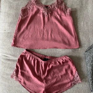 Pyjamasset, H&M, S, rosa - Rosa pyjamasset (linne+shorts) med spets från H&M i storlek S. I mycket fint skick, som ny då använt max 2 ggr. 100% polyester.   Mått linne:  Längd ca 55 cm enligt bild (justerbar till mer/mindre)  Byst ca 45 cm Midja ca 48 cm  Mått shorts: Inre längd ca 5 cm Yttre längd ca 24 cm Midja ca 35 cm (elastisk)  Stuss ca 43 cm