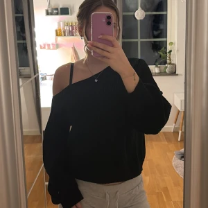 Svart offshoulder tröja - Säljer en stilren svart offshoulder tröja.   Tröjan har långa ärmar och är gjord i ett mjukt material som känns skönt mot huden.