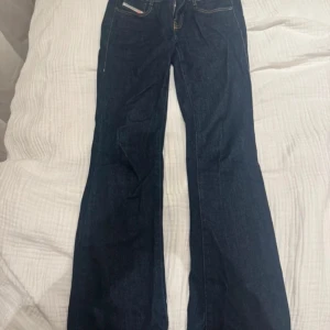 Mörkblå bootcut jeans från Diesel - Snygga mörkblå bootcut jeans från Diesel med klassisk femficksdesign. Jeansen är knappt använda men tyvärr blivit lite missfärgade vid foten för det är för långa på mig.🥰