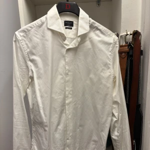 Vit skjorta från Selected Homme - Säljer en stilren vit skjorta från Selected Homme. Skjortan har en klassisk krage och långa ärmar, perfekt för både formella och avslappnade tillfällen. Den är tillverkad i ett mjukt och bekvämt material.