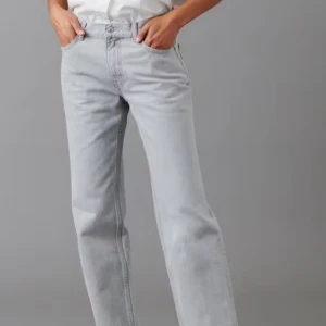 Ljusgrå jeansbyxor - Snygga ljusgrå jeansbyxor med en klassisk straight passform. Byxorna har en låg midja och är perfekta för en avslappnad stil. De har en enkel design med dragkedja och knapp framtill.