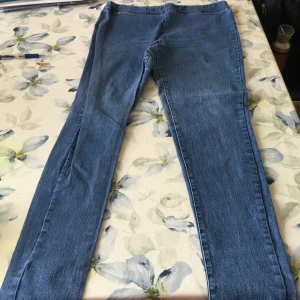 Blå jeansbyxor - Säljer ett par klassiska blå jeansbyxor. De har en rak passform och är tillverkade i ett slitstarkt denimtyg. Jeansbyxorna är stretchiga och är perfekta för en avslappnad stil.