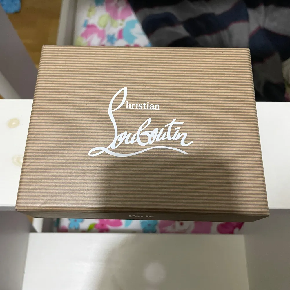 Säljer en elegant svart plånbok från Christian Louboutin. Den har ett stilrent mönster med nitar och flera kortfack. Perfekt för att hålla dina kort organiserade med stil. Kommer i originalförpackning.. Asusteet.