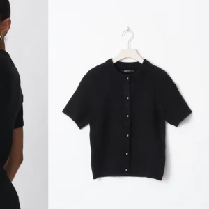 !!!BUDA!!!Svart kortärmad kofta från gina - Snygg svart kofta från gina med korta ärmar och knappar framtill. Perfekt för lager-på-lager eller som ett stilrent plagg i sig. Enkel och stilren design som passar till många olika outfits.