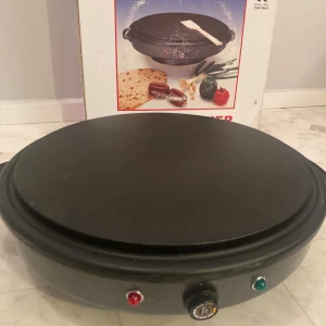 Elektrisk crepepanna - Säljer en elektrisk crepepanna perfekt för att göra tunna och jämna crepes, piroger, pizza osv. Den har en stor rund platta med justerbar temperaturkontroll och indikatorlampor. 