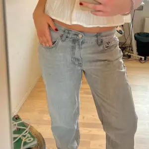 Snygga ljusgråa jeans med en klassisk femficksdesign. De har en knapp och dragkedja framtill och är perfekta för en avslappnad stil. De är lågmidjade nästan lite baggy och straight, storlek 40 men sitter som en 38💞