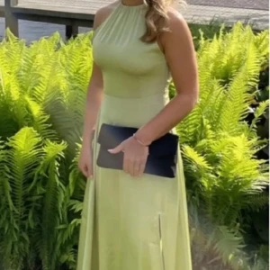 Ljusgrön långklänning med öppen rygg - Grön satinklänning från NA-KD. Endast använd en gång, lite lortig längst ner men inget som syns och går ev bort med fläckborttagning