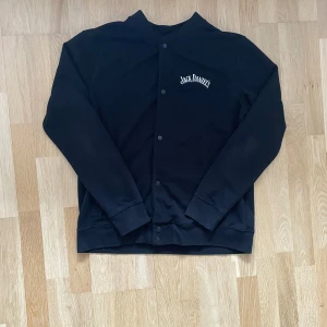 Jack Daniels kofta - Asfet kofta med JD tryck. Den är bara använd enstaka gånger. Bra skick. Storlek Large. Hör av er vid frågor!