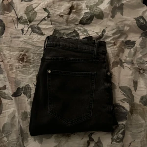 Svarta jeansbyxor - Snygga svarta jeansbyxor med en klassisk femficksdesign. Byxorna har en rak passform och är perfekta för en stilren look. De är tillverkade i ett robust denimtyg och har en midwaist-design för bekväm passform. Nypris:  800kr