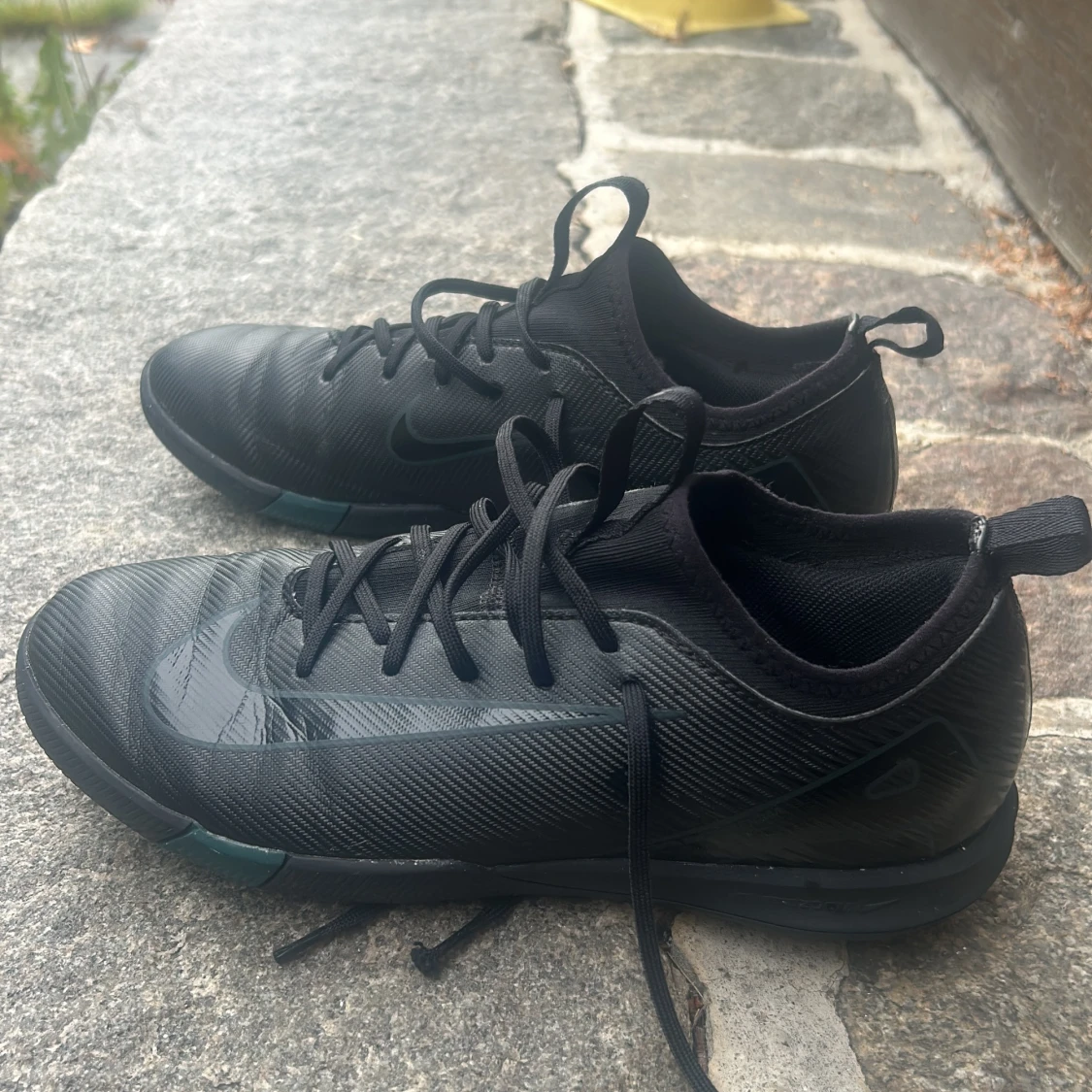 Svarta Nike fotbollsskor med snörning