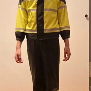 Ett varsel regnställ med reflex - Säljer ett varsel regnställ med reflexdetaljer och svarta muddar. Jackan har dragkedja framtill och är perfekt för dig som vill sticka ut och synas. Passformen är normal och materialet känns som syntet, vilket gör den lätt och smidig. Och byxorna är med hängslen och justerars med dragsko i midjan. Modellen på bilden är 15år och är 158cm lång och kläderna är lite små. Hör av dig.(litet paket)