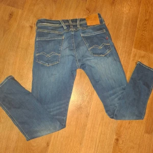 Replay Hyperflex blå jeans W30  - Säljer ett par Replay Hyperflex jeans i klassisk blå tvätt med snygga slitningar och kontrastsömmar. Modellen har raka ben och sköna stretchiga material. Perfekta för dig som gillar en avslappnad men ändå stilren look. Den passar bra på 170-175 cm. De är använda ett fåtal gånger. Nypris 1799 kr