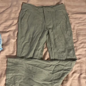 Gråa linnebyxor från Divided - Snygga gråa linnebyxor från Divided med bootcut ben och diskreta fickor fram. Materialet är lätt och andas. Aldrig använda.