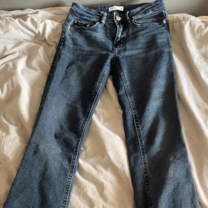 Blå jeans från Gina tricot  Perfect Jeans, stl 32 - Snygga blå jeans från Perfect Jeans i storlek 32. Klassisk femficksmodell med bootcut, har blivit slitna i slutet och en fläck som inte går bort som inge syns. Jeansen är i ett mjukt denimtyg och har en mörkblå tvätt som passar till det mesta.