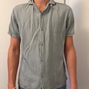 Ljusgrön kortärmad skjorta Strömberg - Säljer en stilren ljusgrön skjorta från Strömberg i storlek S. Skjortan är tillverkad i mjukt lyocellmaterial, har korta ärmar och knäppning framtill. Perfekt för dig som gillar en clean och enkel look.