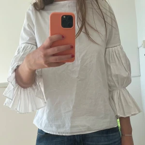 Vit blus med volangärmar från Mango - Supersnygg vit blus från Mango med vida, plisserade volangärmar. 