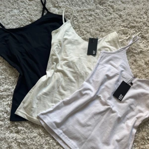 3-pack linne från 157, svart/vit/beige - Tre stilrena linnen från 157 i storlek S, perfekta att matcha till allt. Ett svart, ett vitt och ett mer beiget linne med smala axelband och enkel, något insydd passform. Mjukt bomullsmaterial som känns skönt mot huden. Säljes som paket!