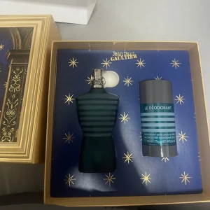 Jean Paul Gaultier Le Male presentbox - Snygg presentbox med Le Male parfym och deodorant från Jean Paul Gaultier. Flaskan har en ikonisk blågrön kropp med ränder och metallkork. Boxen är lyxigt guldig med blått och stjärnmotiv, perfekt som gåva. Använde den 2 gånger, deodorant oanvänd.