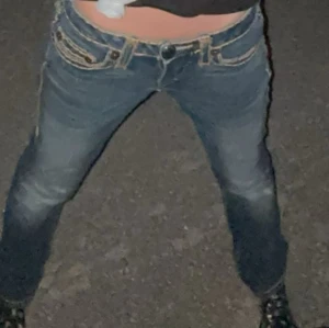 True Religion blå jeans - Jeans med låg midja från true religion. Storlek w27. Har sytt inuti för att kunna justera midjan men det är inget som märks. Säljer eftersom jag knappt använt dem.