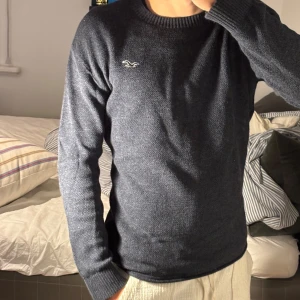 Mörkblå stickad tröja från Hollister - Säljer en mörkblå stickad tröja från Hollister. Skicket är bra. Modellen är 174cm och 63kg.