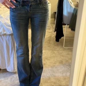 Blå lågmidjade bootcut jeans - Snygga blå jeans med bootcut-modell. 