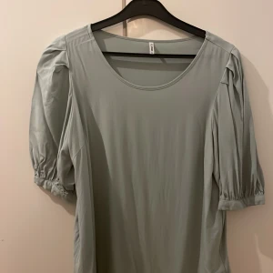 Ljusgrön blus från ONLY - Säljer en ljusgrön blus från ONLY i storlek S. Blusen har puffiga korta ärmar med rynk vid ärmslut och en rundad halsringning. Materialet känns mjukt och lätt, perfekt för alla årstider. Enkel och stilren design som är lätt att matcha.