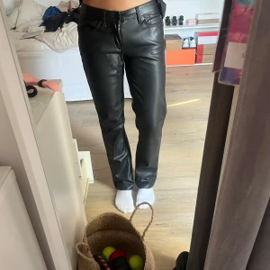 Svarta skinnbyxor från lager 157, XS - Snygga svarta skinnbyxor från 157 i storlek XS. Byxorna har rak passform, klassiska fickor. Materialet är syntetiskt skinn med mjuk insida, perfekt för en edgy look. Stängs med dragkedja och knapp framtill. Super fina! 💗