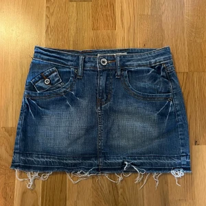 Y2K denim kjol - Oanvänd mini jeans kjol i y2k stil! Storlek 25 och sitter som XS. Den är 75 cm i midjemått! Det är bara att skriva om du har några funderingar! <3 