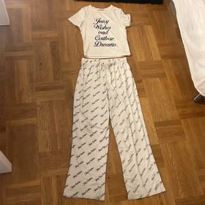 Juicy Couture loungebyxor XS - Äkta juciy couture Mysiga loungebyxor och tröja från Juicy Couture i vitt med svart logotypmönster över hela byxan. Och svart text på tröjan med Byxorna har resår i midjan och är raka i modellen, perfekta för chill dagar hemma. Materialet är mjukt och stretchigt för extra komfort. Köpte för 1200