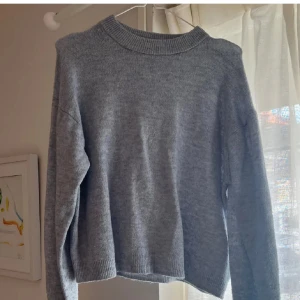 Blå stickad tröja från H&M - Säljer en enkel och snygg blå stickad tröja från H&M i storlek S. Tröjan har rund hals, ribbade muddar och lång ärm. Perfekt att slänga på sig när det är lite kyligt ute. Passar dig som gillar en clean och chill stil.