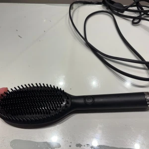 ghd Glide värmeborste svart - Säljer en svart ghd Glide värmeborste som är perfekt för att snabbt styla och släta ut håret. Har knappt andvänt borsten och den är i bra skick