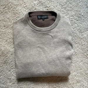 Ljusbeige ulltröja - Säljer denna snygga ljusbruna/beigea stickade ulltröjan i 100% ull från det italienska lyxmärket Lagency. Köptes ny i Italien för 2700kr. Aldrig använd och helt sprillans ny. 