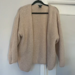 Beige/ gräddvit stickad kofta från Lindex - Mysig och oversized beige/ gräddvit stickad kofta från Lindex. Koftan har lång ärm, öppen framtill utan knappar och är tillverkad i ett fluffigt och mjukt material. Perfekt att slänga på sig när det är kyligt ute. Passar dig som gillar en avslappnad och chill stil. Sparsamt använd så skicket är toppen.