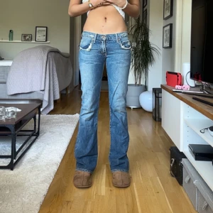Lågmidjade blåa bootcut jeans  - Säljer mina lågmidjade Chip& pepper jeans med slitna detaljer på bakfickorna och råa kanter då dem inte riktigt är min stil och därav inte kommer till användning. Pris kan diskuteras💞! Jag är 170 cm och jeansmåtten är: Innerbenslängden: 80 cm Midjemåttet: 38 cm Grenen: 20 cm 
