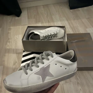 Vita sneakers från golden goose  - Snygga vita sneakers från golden goose. Skorna har rund tå, platt sula och klassisk snörning. Perfekta för en stilren och trendig look.