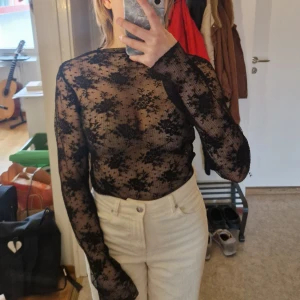 Svart meshtopp med blommönster från Gina Tricot - Säljer en meshad svart spetstop från Gina Tricot med blommigt mönster. Helt oanvänd, säljer då den tyvärr var för stor i ärmarna för min smak. Snygg och trendig topp som ger en cool look! Skriv vid frågor!✨️ Samfraktar gärna så kika in mina andra inlägg!✨️