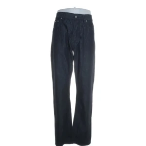 Svarta jeansbyxor med raka ben - Säljer ett par mörkblå Hugo boss  jeansbyxor med klassisk femficksdesign och raka ben. Byxorna har knappar och dragkedja i gylfen och är perfekta för en stilren look. Passar dig som gillar enkel och tidlös stil.